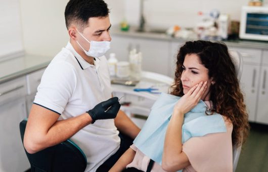 femme qui ressent une sensibilité dentaire