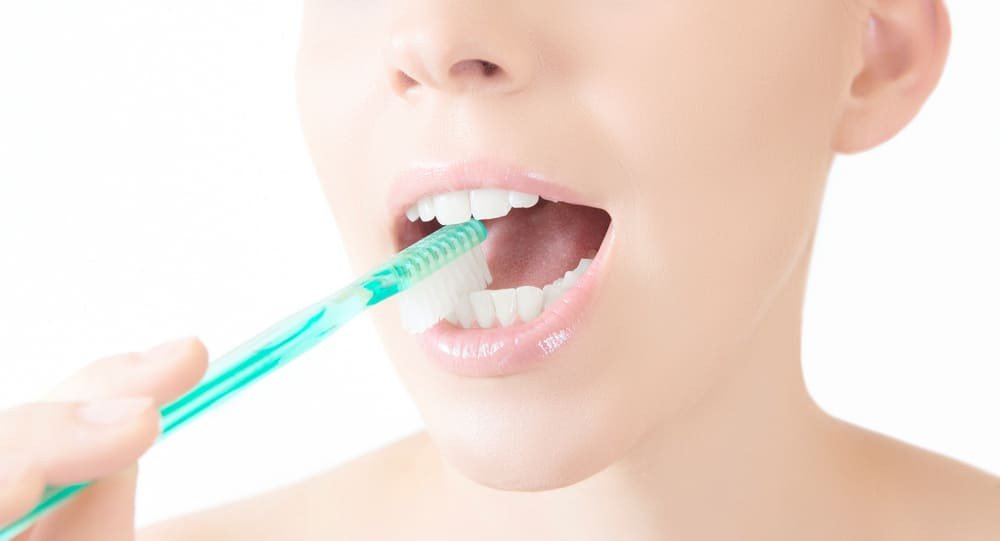 femme qui se brosse les dents de devant