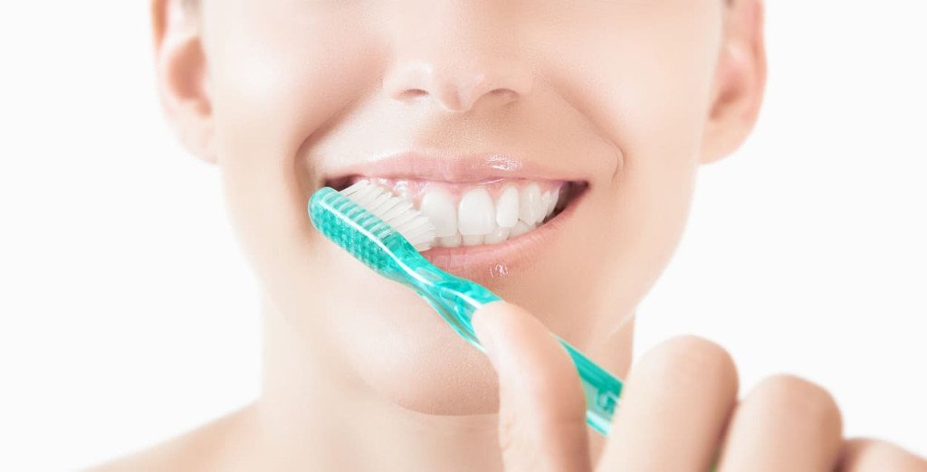 femme qui se brosse la surfaces extérieures des dents