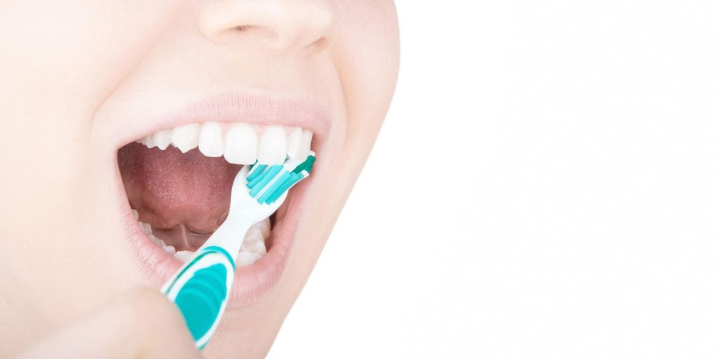 femme qui se brosse la surfaces intérieures des dents
