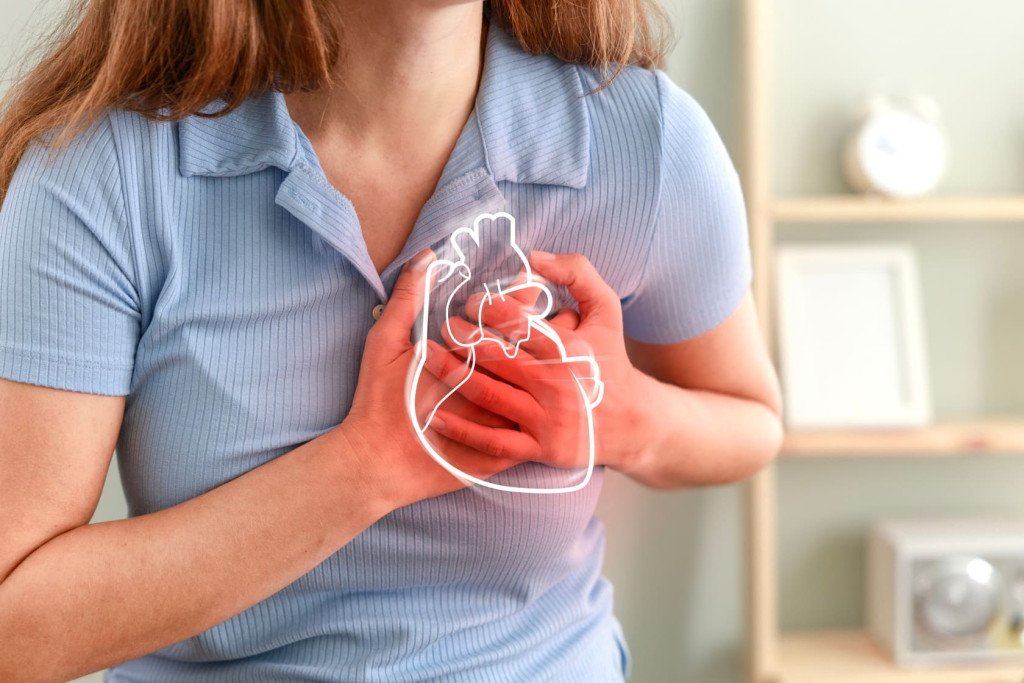 Une femme tenant sa poitrine avec un dessin linéaire blanc d'un cœur superposé, symbolisant peut-être des douleurs cardiaques ou la conscience de la santé cardiovasculaire.