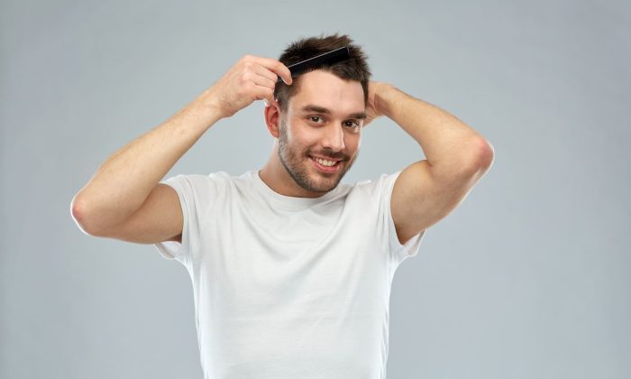 Un homme souriant se peigne les cheveux, illustrant la réussite des étapes de la greffe de cheveux.