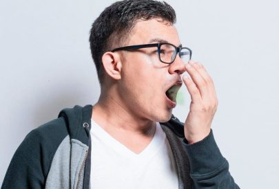 Un homme se couvre la bouche avec la main, illustrant le problème de la mauvaise haleine.
