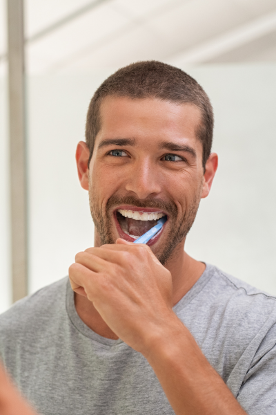 homme content lors du brossage de dents