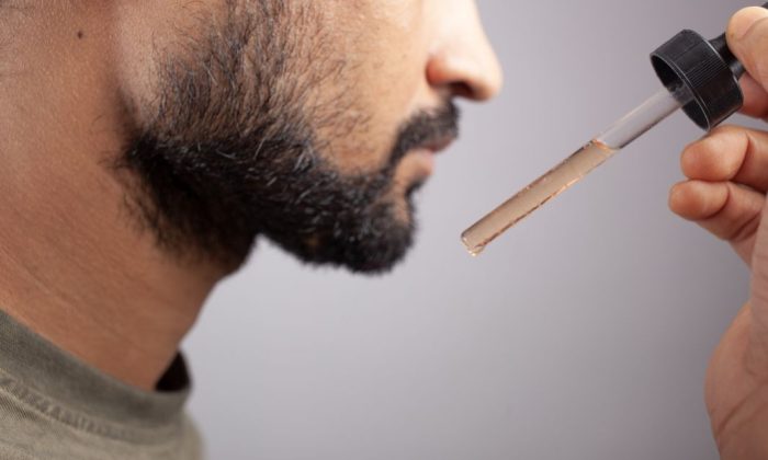 homme qui met du minoxidil pour faire pousser sa barbe